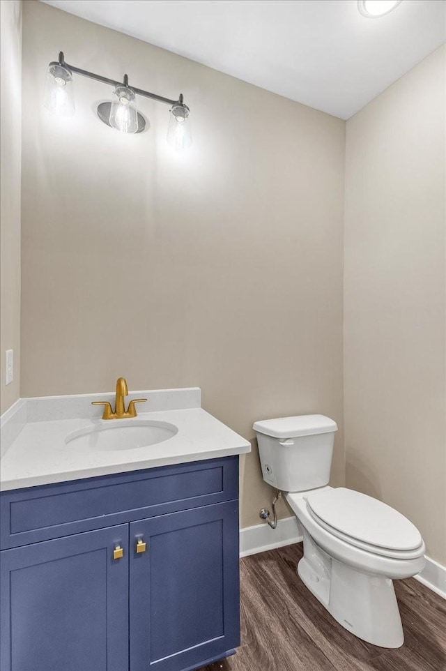 bathroom with vanity, wood-type flooring, and toilet