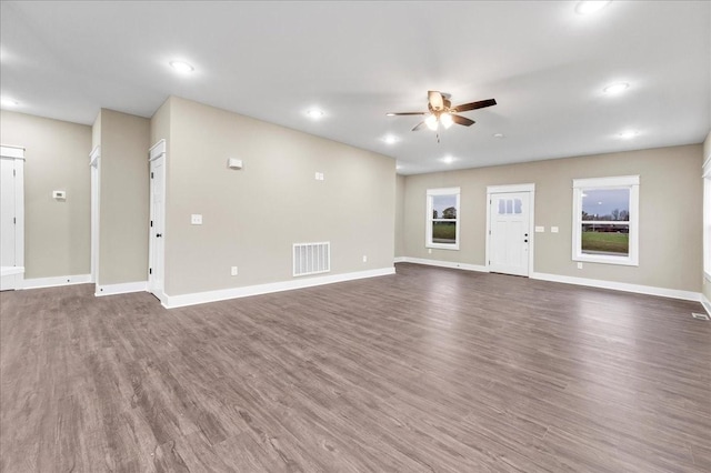 unfurnished living room featuring ceiling fan and dark hardwood / wood-style floors