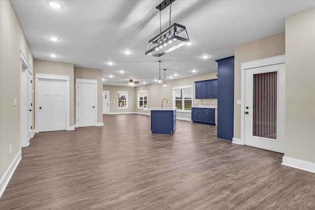 unfurnished living room with ceiling fan, sink, and dark hardwood / wood-style floors