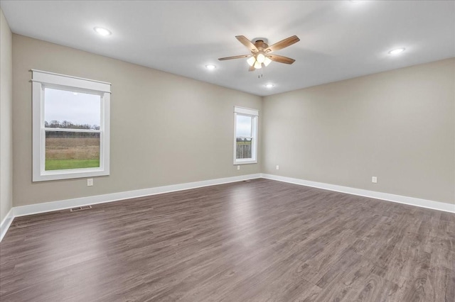 empty room with ceiling fan and dark hardwood / wood-style flooring