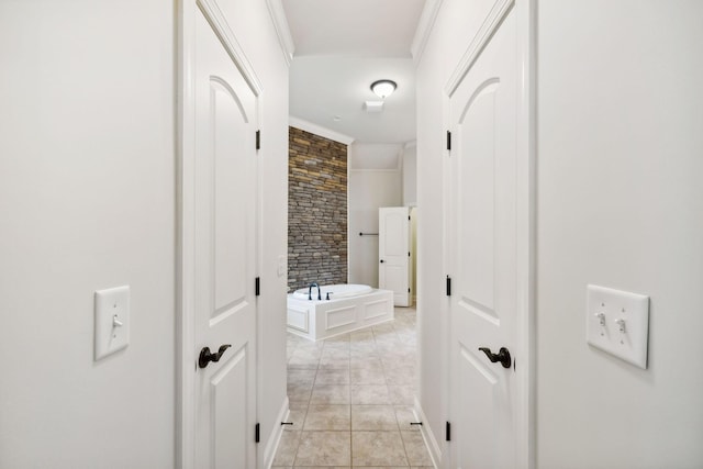 hall with light tile patterned floors and ornamental molding