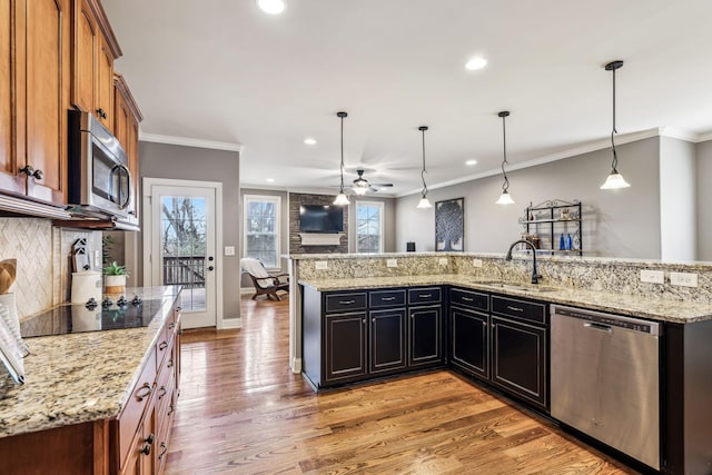 kitchen featuring pendant lighting, sink, ceiling fan, ornamental molding, and stainless steel appliances