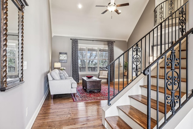 staircase with ceiling fan, crown molding, and wood-type flooring