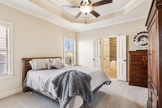 bedroom with ensuite bathroom, crown molding, ceiling fan, a tray ceiling, and light colored carpet