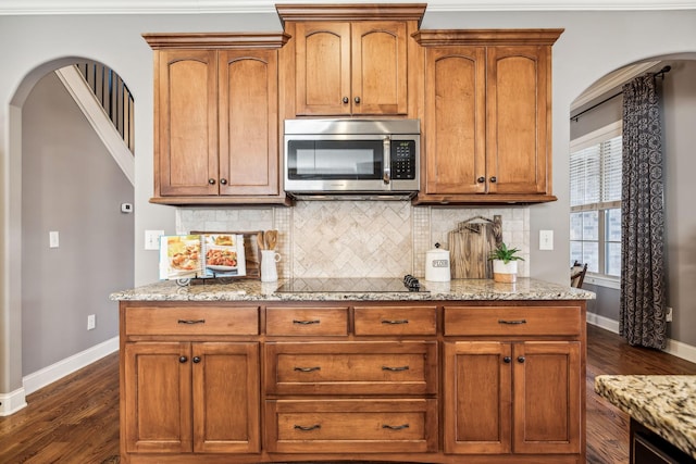 kitchen with backsplash, dark hardwood / wood-style flooring, light stone counters, and black electric stovetop