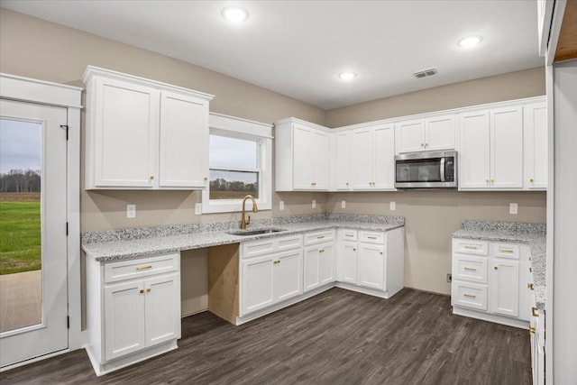 kitchen with dark hardwood / wood-style floors, white cabinetry, and sink