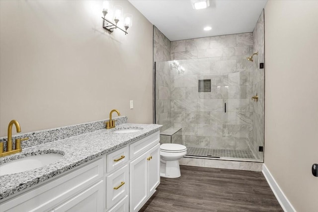 bathroom featuring hardwood / wood-style flooring, toilet, vanity, and walk in shower