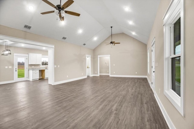 unfurnished living room featuring dark hardwood / wood-style floors, high vaulted ceiling, and ceiling fan