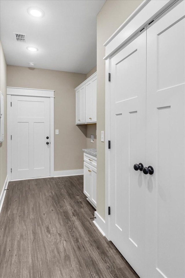 clothes washing area with dark wood-type flooring