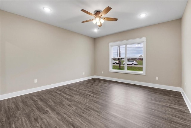 spare room featuring dark hardwood / wood-style flooring and ceiling fan