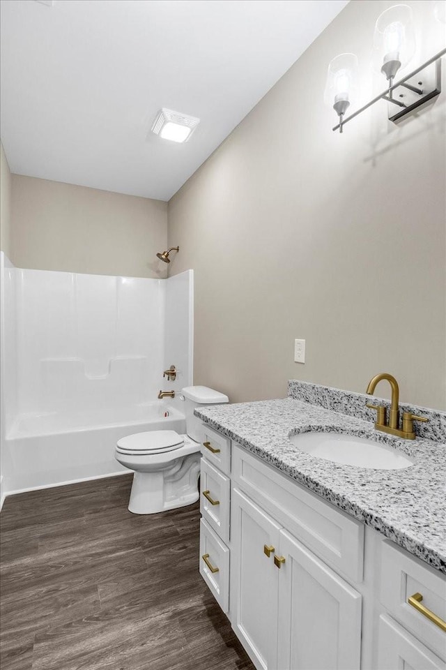 full bathroom featuring vanity, toilet, wood-type flooring, and shower / washtub combination