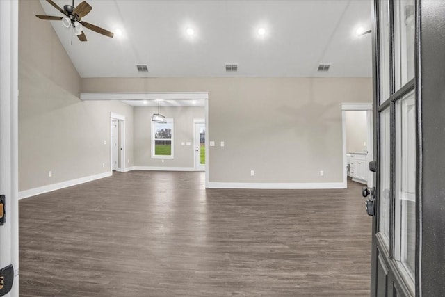 unfurnished living room featuring ceiling fan, dark wood-type flooring, and vaulted ceiling