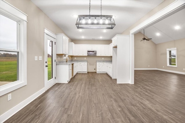 kitchen featuring dark hardwood / wood-style flooring, white cabinetry, ceiling fan, and sink