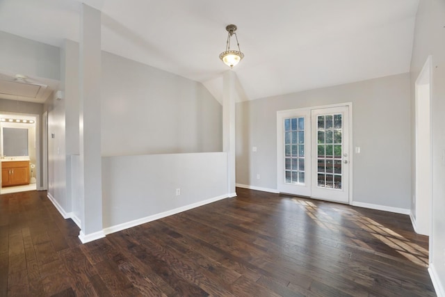 empty room with vaulted ceiling and dark hardwood / wood-style floors