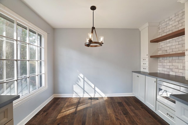 unfurnished dining area featuring dark hardwood / wood-style floors and a chandelier