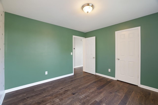 unfurnished bedroom with dark hardwood / wood-style flooring