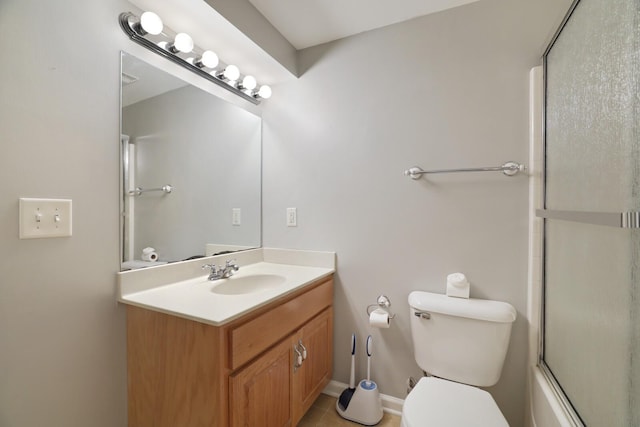 full bathroom with tile patterned floors, vanity, toilet, and bath / shower combo with glass door