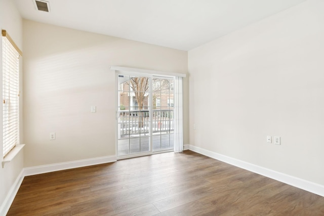 unfurnished room with plenty of natural light and dark hardwood / wood-style floors