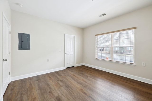 unfurnished room with electric panel and dark wood-type flooring