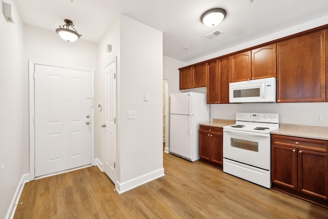 kitchen featuring light hardwood / wood-style flooring and white appliances