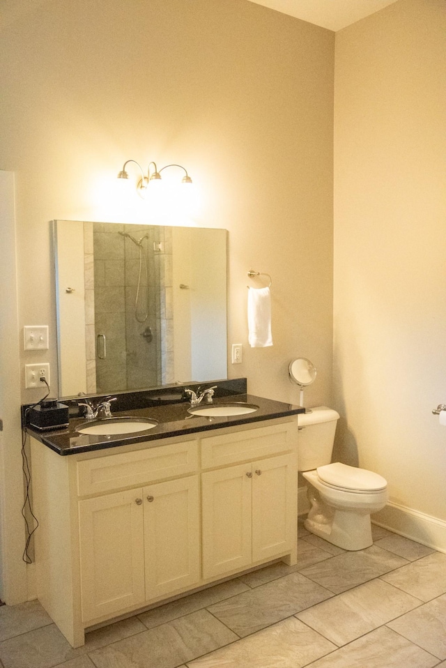 bathroom with tile patterned flooring, vanity, toilet, and a shower with door