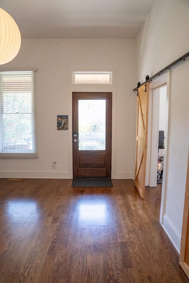 entrance foyer featuring a barn door and dark hardwood / wood-style flooring