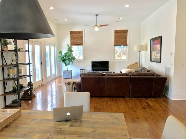 living room with ceiling fan and light hardwood / wood-style flooring