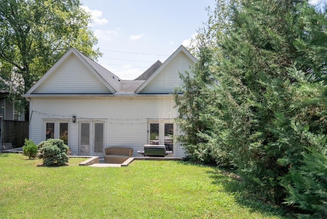 rear view of property featuring french doors and a lawn