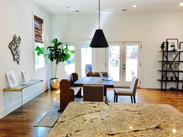 dining space featuring plenty of natural light, dark wood-type flooring, and french doors