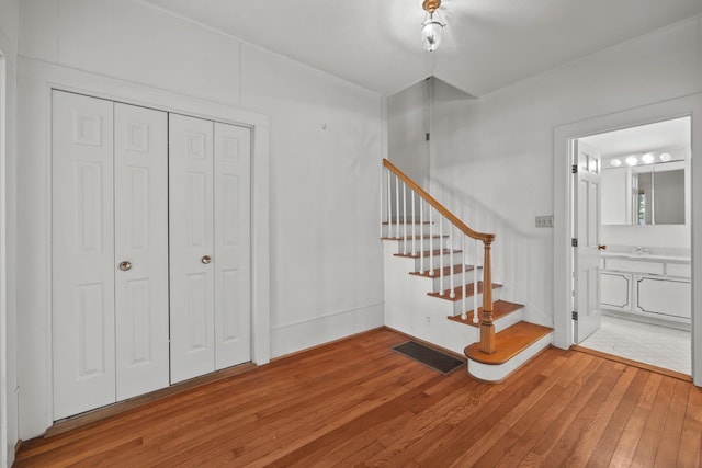 staircase featuring hardwood / wood-style floors and sink