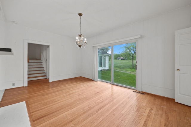 unfurnished dining area featuring light hardwood / wood-style floors and an inviting chandelier