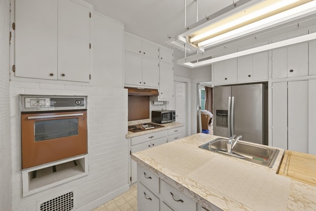 kitchen featuring appliances with stainless steel finishes, white cabinetry, and sink