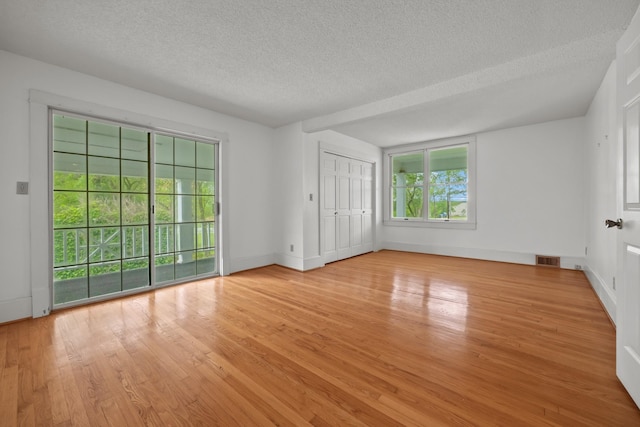 empty room featuring light hardwood / wood-style floors and a textured ceiling