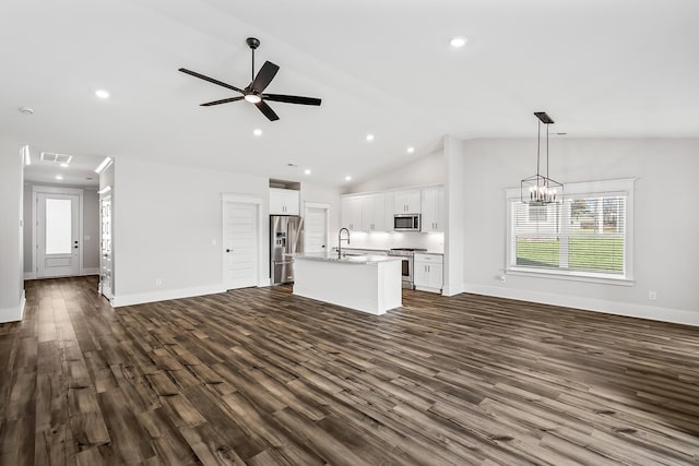 unfurnished living room featuring dark wood-type flooring, lofted ceiling, ceiling fan with notable chandelier, and sink