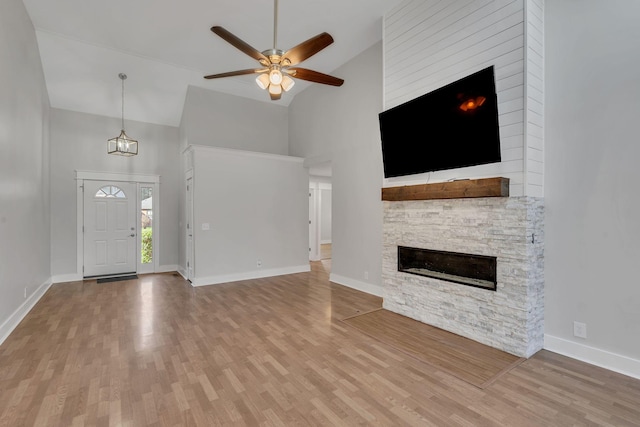 unfurnished living room with hardwood / wood-style floors, ceiling fan, a fireplace, and high vaulted ceiling