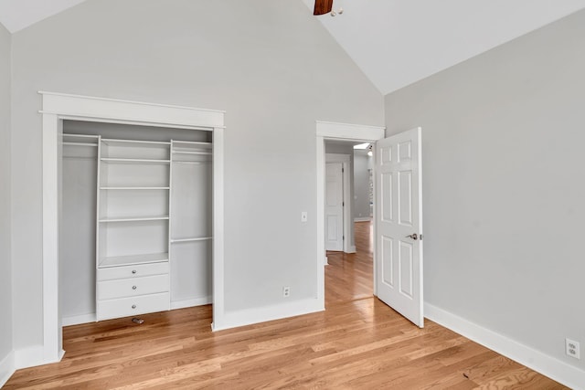 unfurnished bedroom featuring light wood-type flooring, high vaulted ceiling, a closet, and ceiling fan