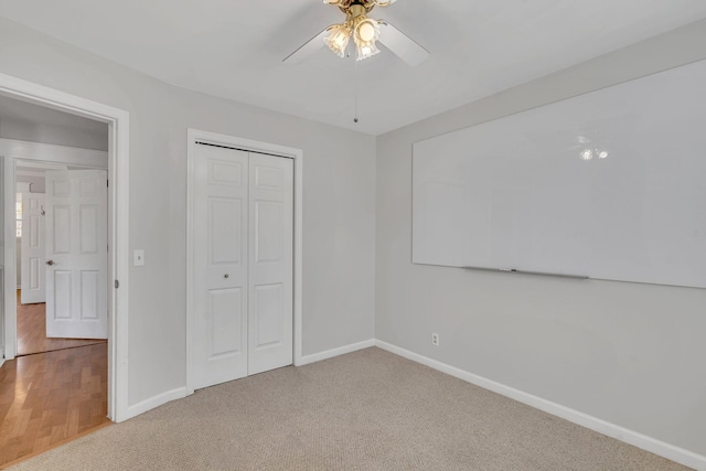 unfurnished bedroom with ceiling fan, carpet floors, and a closet