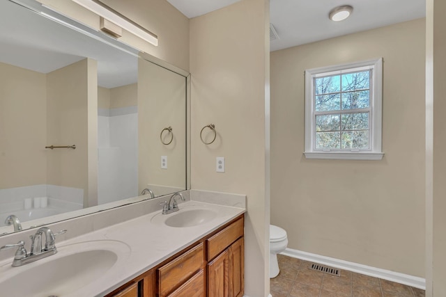 bathroom featuring tile patterned floors, vanity, a bath, and toilet