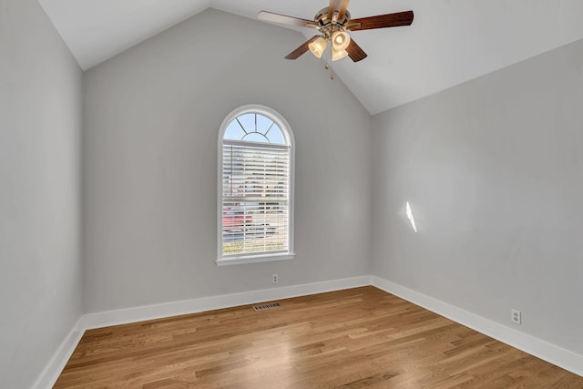 empty room featuring light hardwood / wood-style flooring, vaulted ceiling, and ceiling fan