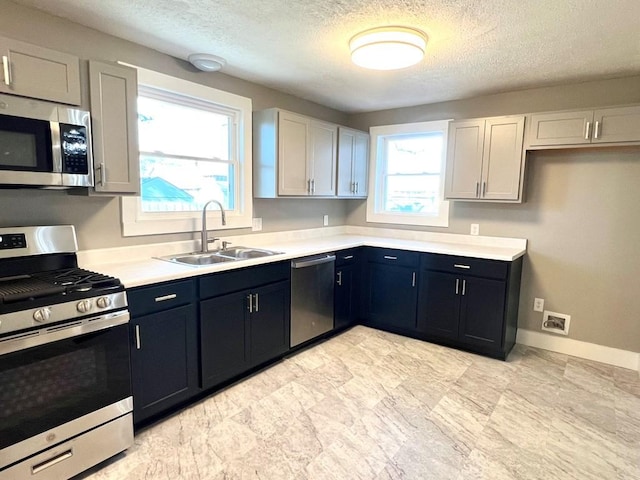 kitchen featuring a textured ceiling, sink, white cabinetry, and stainless steel appliances