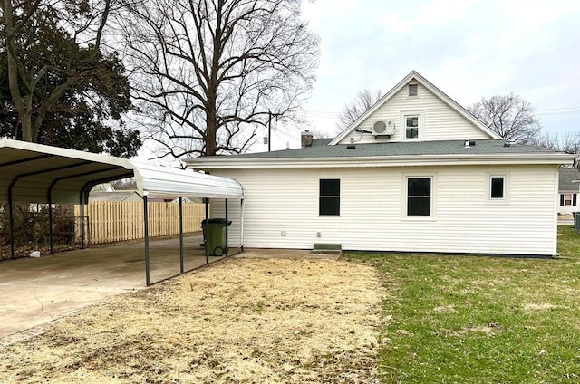 rear view of property with a yard and a carport