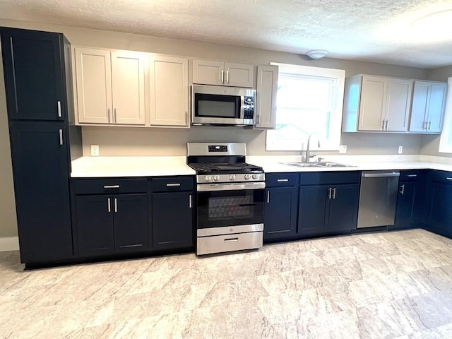 kitchen featuring a textured ceiling, stainless steel appliances, white cabinetry, and sink