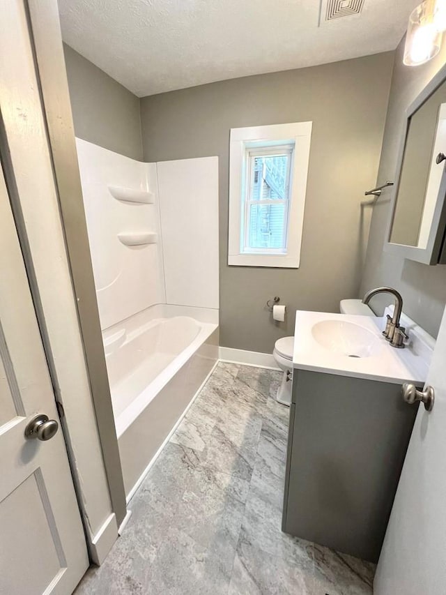 full bathroom with a textured ceiling, vanity, toilet, and shower / bathtub combination