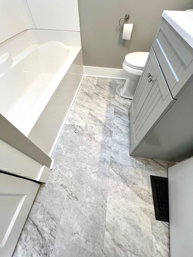 bathroom featuring a bath, vanity, and toilet