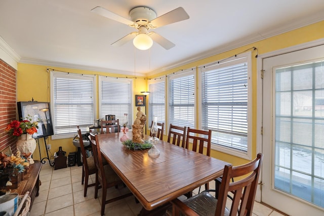 tiled dining space featuring ceiling fan, a healthy amount of sunlight, and ornamental molding