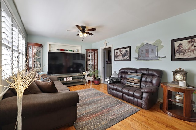 living room with wood-type flooring and ceiling fan