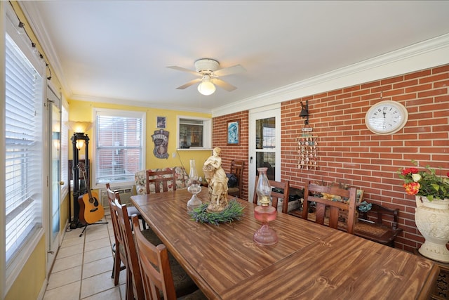 dining room with brick wall, ceiling fan, light tile patterned floors, and crown molding