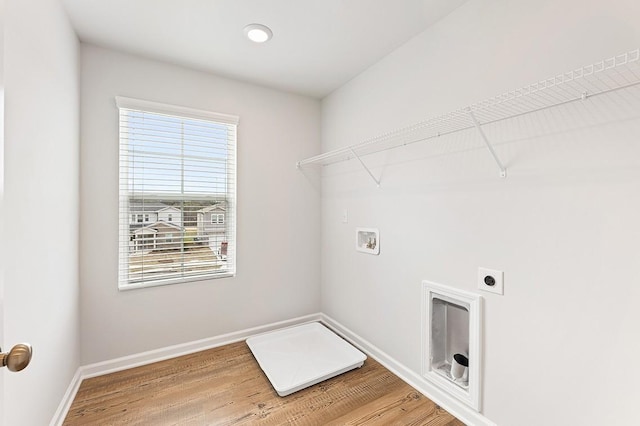 washroom with hookup for an electric dryer, hookup for a washing machine, and wood-type flooring