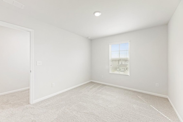 spare room featuring light carpet