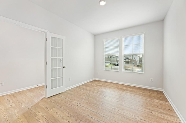 empty room with light wood-type flooring and french doors